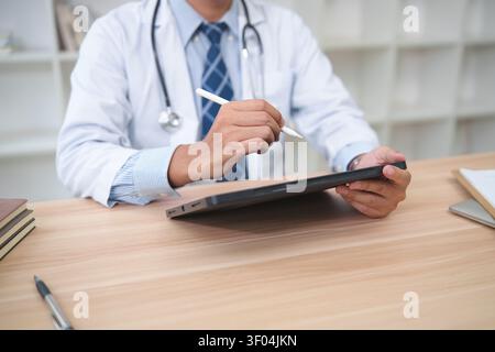 Healthcare Professional Using Tablet for Digital Record Keeping Stock Photo