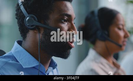 Close up African American business man operator typing computer keyboard talking with headset work negotiation consulting trading with helpline Stock Photo
