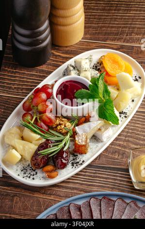 Gourmet cheese board with assorted fruits and nuts Stock Photo