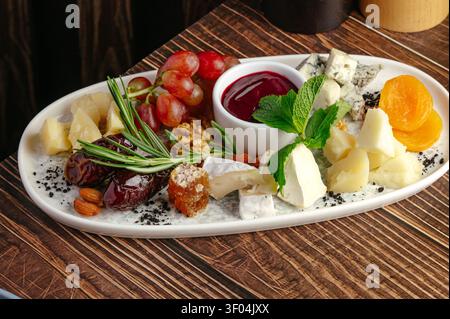 Gourmet cheese board with assorted fruits nuts and jam Stock Photo