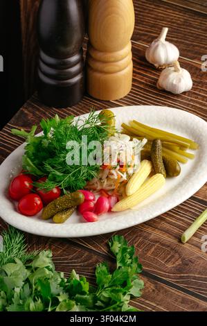 Platter of assorted pickled vegetables and fresh herbs Stock Photo