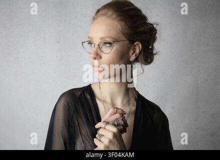 Elegant woman in cat eye glasses looking pensive Stock Photo