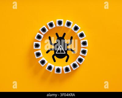Bug icon with warning sign surrounded by shield icons, symbolizing digital protection and network security against malware threats Stock Photo