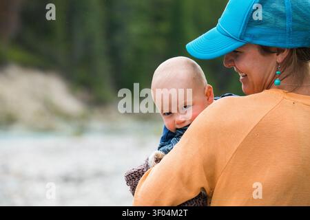 Baby peeking over his mothers shoulder Stock Photo