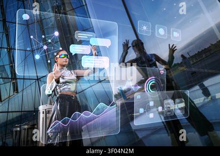 Woman in futuristic clothes interacts with holographic interface Stock Photo