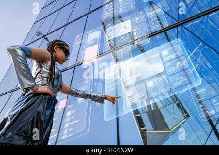 Woman in futuristic clothing using holographic interface Stock Photo
