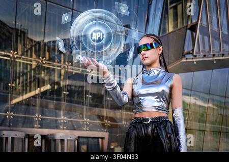 Young woman interacts with futuristic API hologram Stock Photo