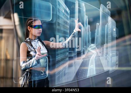 Young woman in futuristic clothes interacts with holographic city map Stock Photo