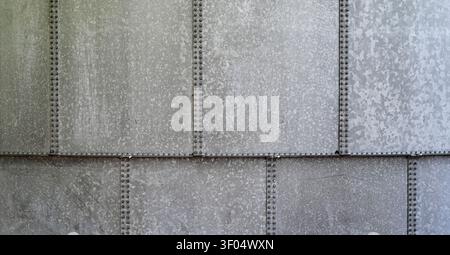 Close up weathered galvanized metal water tank surface with six vertical seams and one horizontal seam with nuts and bolts Stock Photo