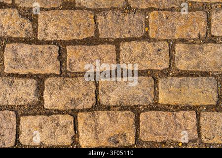 Top view of old brown cobblestone pavement with a rough granite stone brick texture, background element Stock Photo