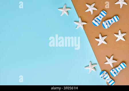 Beach sandals and starfish on brown sand with blue sea background and copy space Stock Photo
