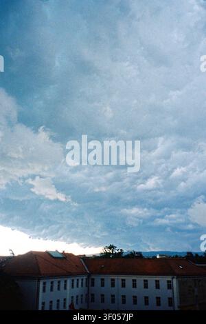 Analog photograph of the Archives of Vojvodina building beneath dense storm clouds gathering before rain. Stock Photo