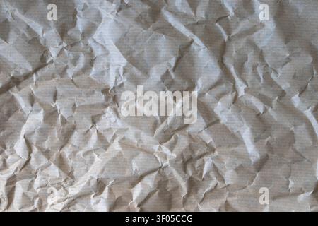 Beige crumpled paper background with subtle lighter horizontal stripes. Soft neutral textured surface for design, branding, packaging and creative pro Stock Photo