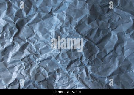 Blue crumpled paper background with subtle lighter horizontal stripes. Textured backdrop for design, branding, packaging and creative projects. Stock Photo