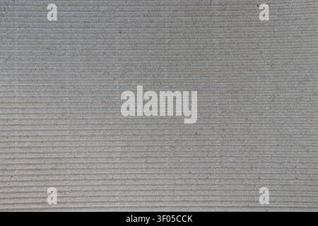 Brown corrugated cardboard background with horizontal stripes and visible dark fibers. Industrial textured surface for packaging, eco design, shipping Stock Photo
