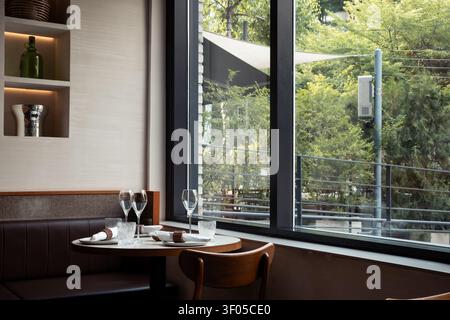 Elegant Table Setting by the Window in a Modern Restaurant Stock Photo