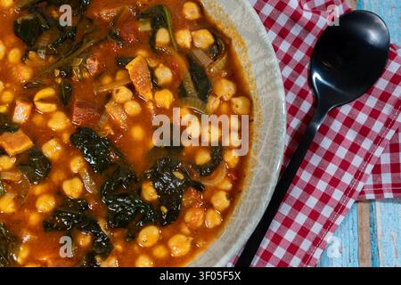 Hearty chickpea stew with chorizo, spinach, and onion simmering in a rich tomato broth, offering a comforting meal Stock Photo