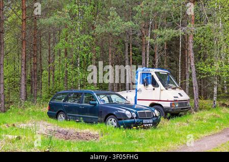 Old abandoned junk cars in the forest Stock Photo
