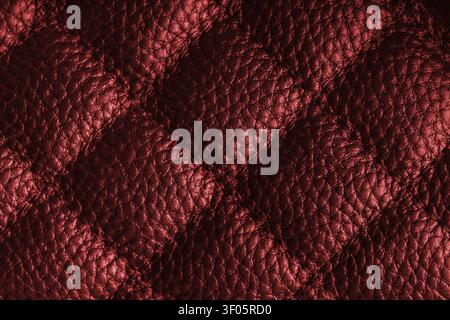 Close up, macro of red quilted leather texture with stitched diamond pattern, luxury material surface shining metal effect for fashion, upholstery or Stock Photo