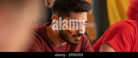 Worried football fans supporting spanish national team in live soccer match at stadium. Stock Photo