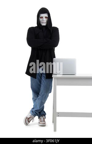 Hacker in mask with laptop on table against white background Stock Photo