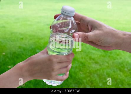 hands are holding a clear plastic water bottle filled with water Stock Photo