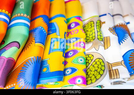 Close up of folded colorful silk scarves with vibrant geometric patterns and artistic prints on white background Stock Photo