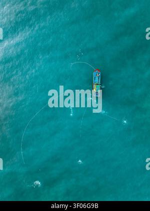 Aerial view of a fishing boat navigating the calm waters of a fjord in ...
