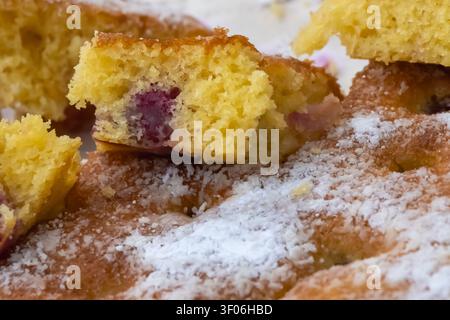 Close-up of homemade cherry sponge cake with powdered sugar, revealing soft fluffy crumb and juicy fruit filling, perfect for bakery, dessert and reci Stock Photo