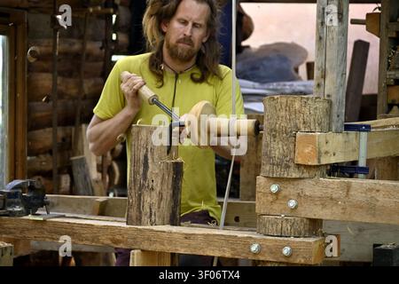Geoff Hannis turning outside of bowl using pole lathe in outdoor workshop at Bristol Avon Wildlife Trust Grow Wilder Stock Photo