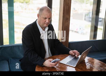 Businessman using smartphone and laptop at workplace Stock Photo
