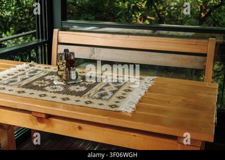 A traditional condiment set with oil, vinegar, salt and pepper placed on a wooden restaurant table. Rustic table decor creates a cozy dining Stock Photo
