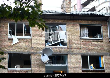 Severely damaged residential building facade with shattered windows and broken frames Stock Photo