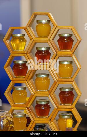 Selection of Natural Organic Bee Honey in Small Glass Jars at Wooden Shelf Stock Photo