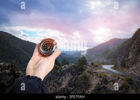 HIker holding compass in hand against mountains, closeup Stock Photo