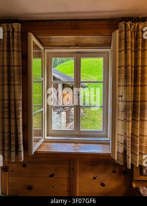 Window view to a green alpine valley landscape Stock Photo