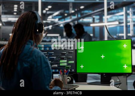 Data center administrator works with a chroma key computer, using an editable screen to repair technical issues. Stock Photo