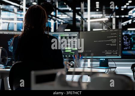 Data center programmer uses a computer to write code for AI systems, working with AI technology and high performance systems. Stock Photo