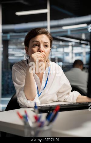 Computer scientist uses a desktop computer in a data center to run hardware diagnostics and maintain operational stability. Stock Photo