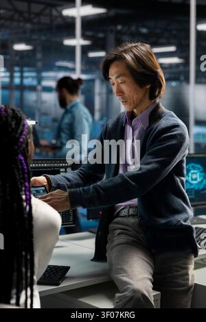 Manager and trainee resolves server connection problems in a server room with artificial intelligence support. Stock Photo