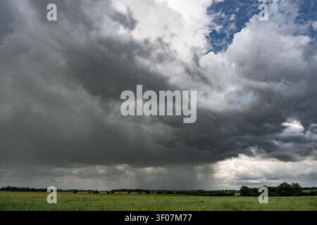 Dark rain clouds over rural landscape before summer thunderstorm Stock Photo