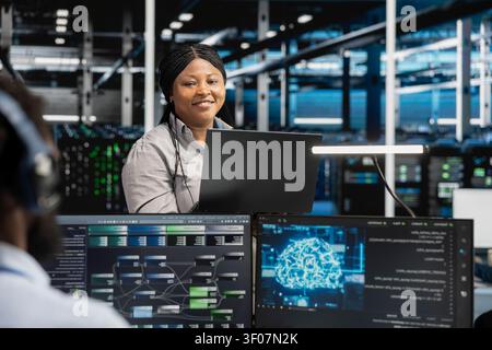 Pleased data center software developer celebrates after configuring machine learning systems with AI technology in a data center. Stock Photo