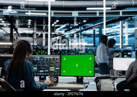 Data center engineer works with a chroma key computer, using an editable screen to repair technical issues. Stock Photo