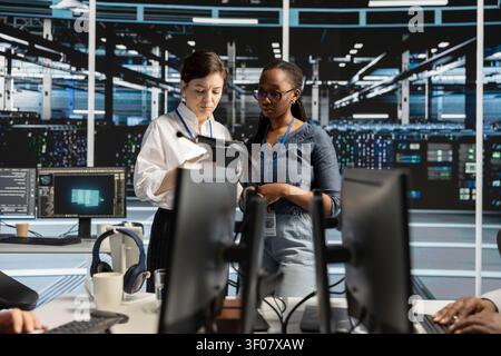 Excited data center engineer celebrates successful AI implementation and improved system results in a server hub. Stock Photo