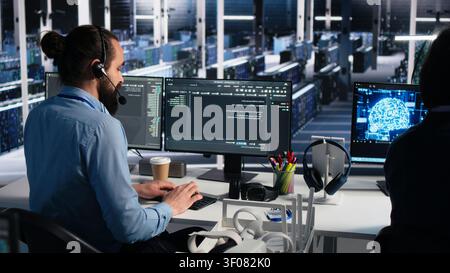 Administrator uses an AI assistant in a server farm to provide technical support and user troubleshooting. Stock Photo