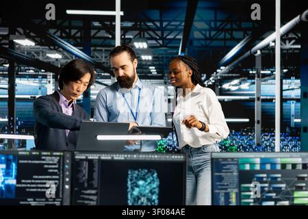 Team of engineers in data infrastructure center tracking AI applications, refining machine learning, while staff members performing load balancing, enhancing AI software operational performance. Stock Photo