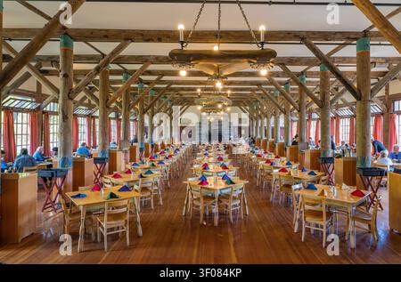 Washington state, United States, JUN 22, 2026 - A large dining hall with high timber-framed ceilings, wooden floors, and rows of tables set with color Stock Photo