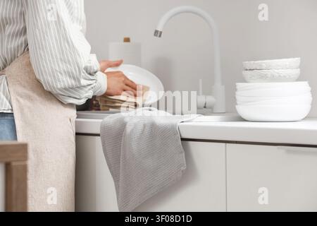 Person drying dishes in modern kitchen Stock Photo