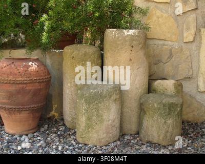 Historic architectural elements made of stone, including pieces of 16th-century columns, alongside a decorative vase from the 1960s, displayed Stock Photo