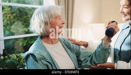 Dumbbell, rehabilitation and senior woman with therapist in retirement home for healthcare or wellness. Help, recovery and weight with old person in Stock Photo